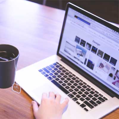 Ragazza al pc portatile con tazza di t&egrave;